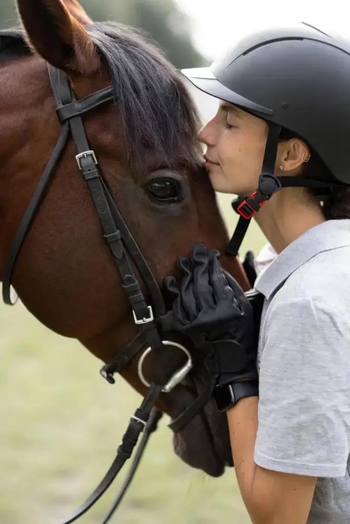 Una jinete acaricia a su caballo